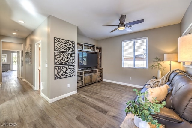 living room featuring wood-type flooring and ceiling fan