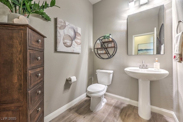 bathroom featuring hardwood / wood-style flooring and toilet