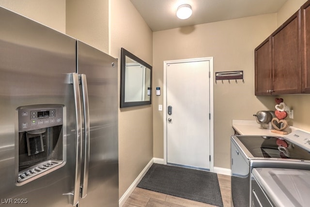 kitchen with stainless steel refrigerator with ice dispenser, dark brown cabinets, and washer and dryer