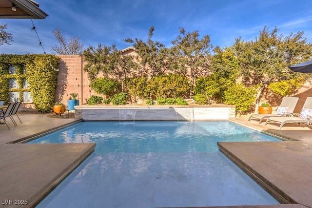 view of swimming pool with pool water feature and a patio