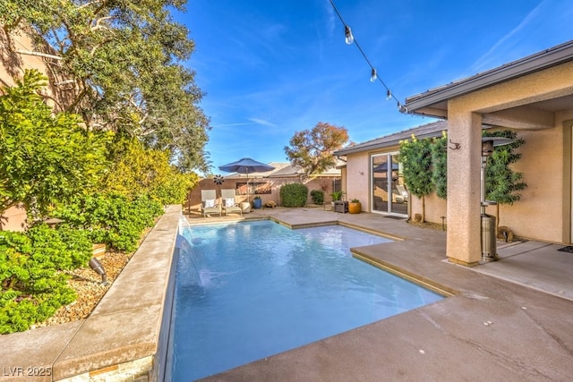 view of pool featuring pool water feature and a patio area