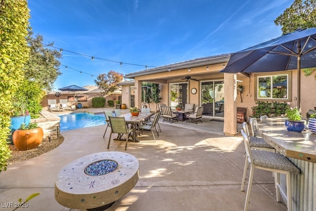 view of patio with ceiling fan and a fire pit