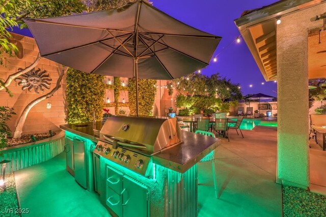 view of patio with area for grilling, a grill, and a swimming pool