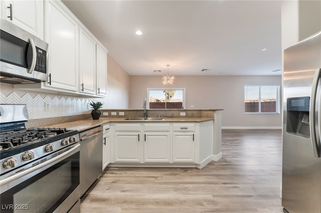 kitchen with stainless steel appliances, white cabinets, and kitchen peninsula