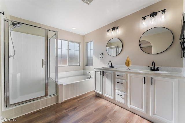 bathroom featuring hardwood / wood-style flooring, vanity, and separate shower and tub