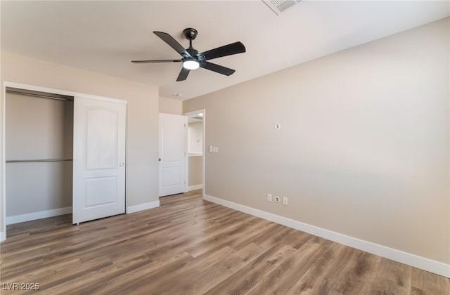 unfurnished bedroom featuring ceiling fan, wood-type flooring, and a closet