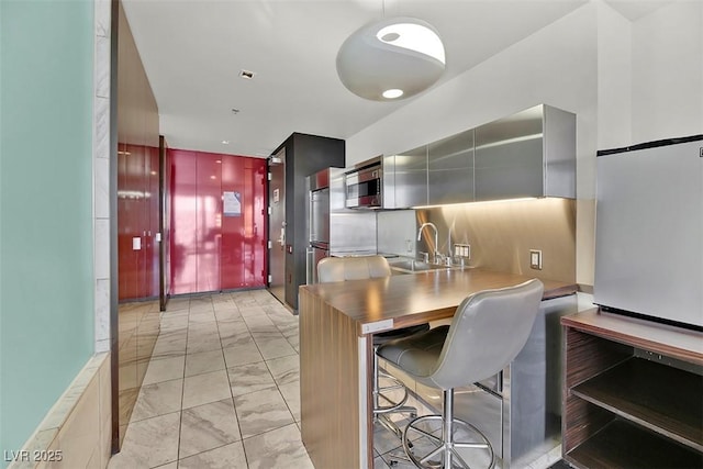 kitchen with sink, backsplash, and a kitchen bar