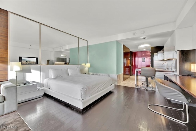 bedroom featuring wood-type flooring and sink