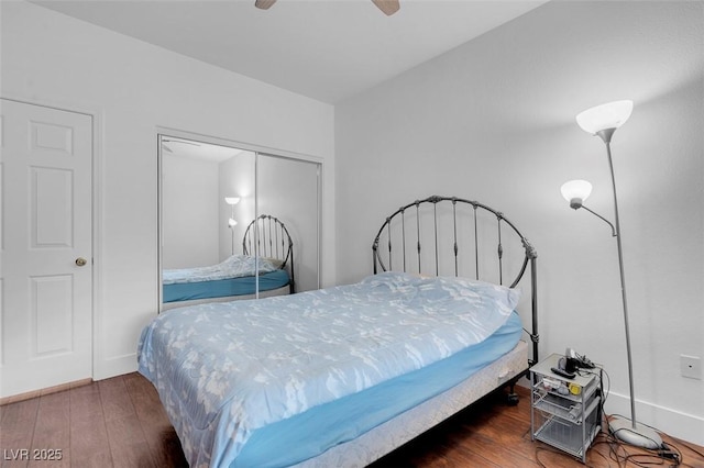 bedroom with dark wood-type flooring, ceiling fan, and a closet