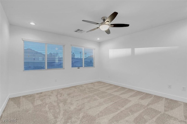 spare room featuring light colored carpet and ceiling fan