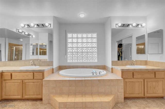 bathroom with a stall shower, a bath, and two vanities