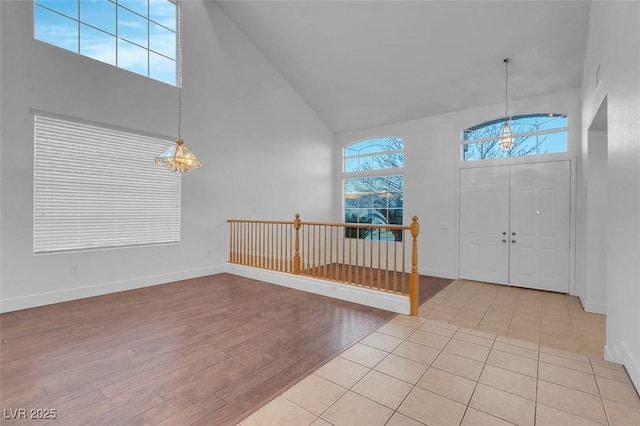 entrance foyer with light wood-type flooring and high vaulted ceiling