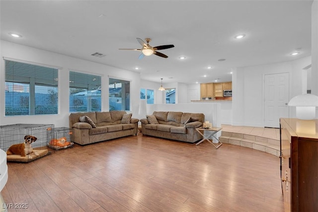 living room with ceiling fan, light wood-style flooring, and recessed lighting