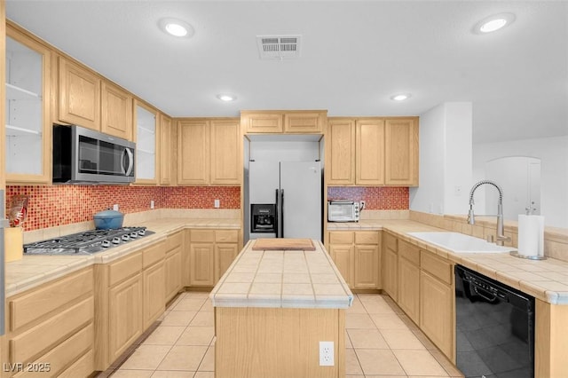 kitchen featuring light brown cabinetry, sink, tile counters, and stainless steel appliances