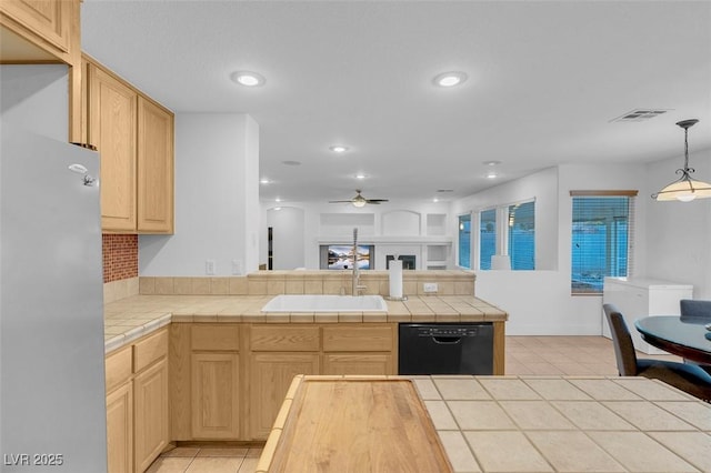 kitchen with light brown cabinetry, sink, stainless steel fridge, and dishwasher