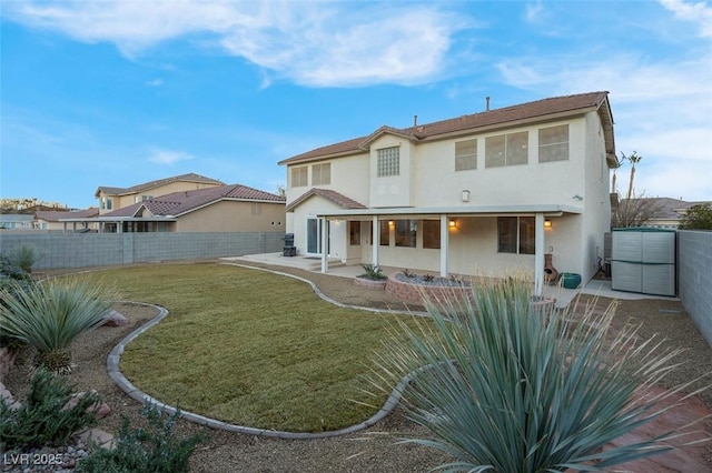 rear view of house with a patio and a lawn