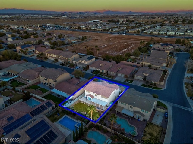 aerial view at dusk of a residential view, property boundaries highlighted, and a mountain view