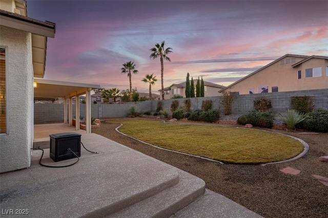 yard at dusk featuring a patio area