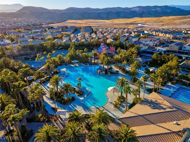 aerial perspective of suburban area with a mountain backdrop and a pool