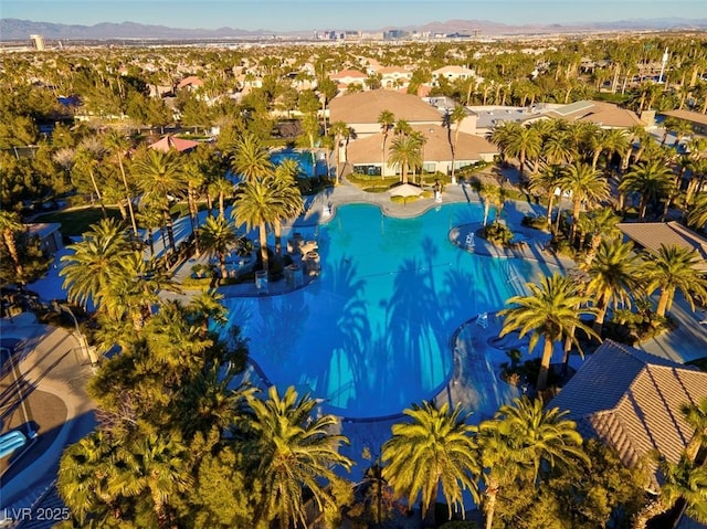 aerial view of residential area with a mountainous background and a pool area