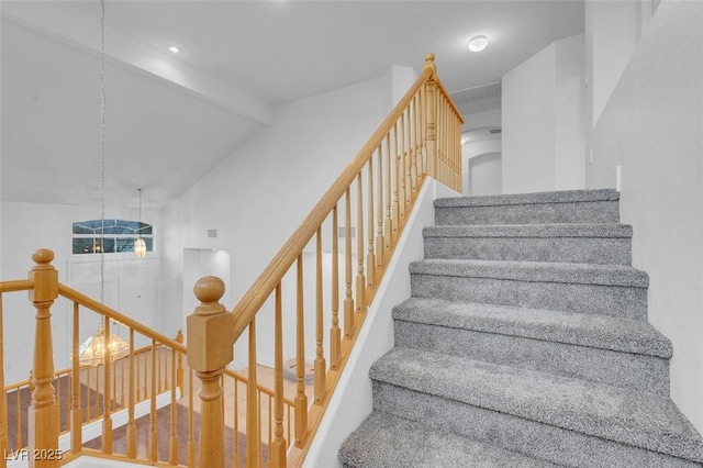 staircase with hardwood / wood-style flooring, lofted ceiling with beams, and a notable chandelier