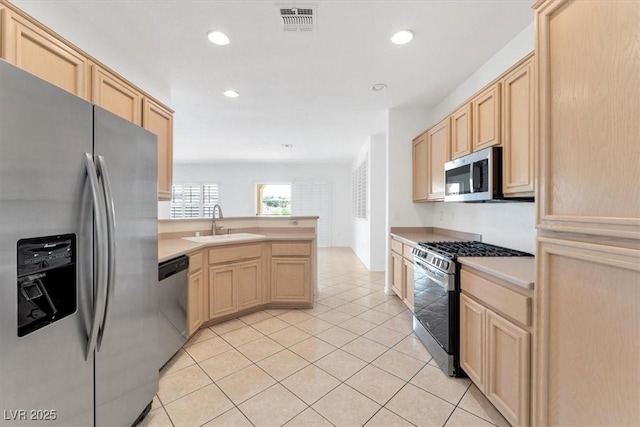 kitchen featuring light brown cabinetry, sink, light tile patterned flooring, and appliances with stainless steel finishes