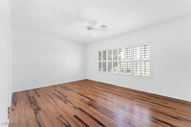 empty room with hardwood / wood-style flooring and ceiling fan