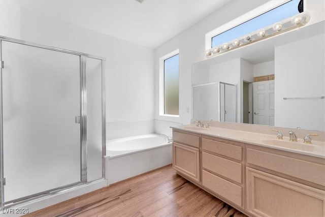 bathroom with independent shower and bath, wood-type flooring, and vanity