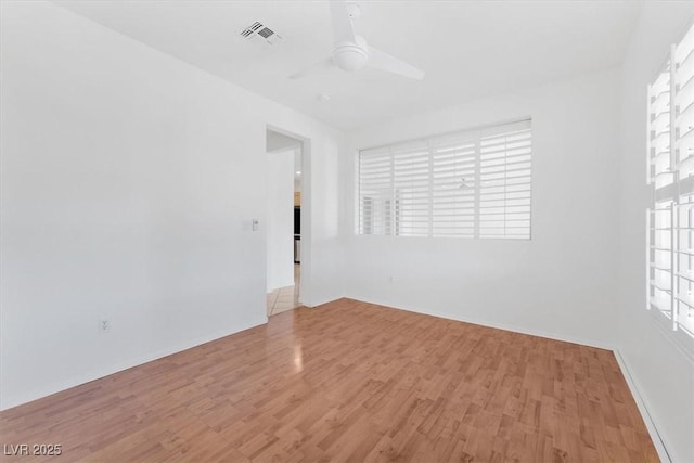 empty room with ceiling fan and light hardwood / wood-style floors