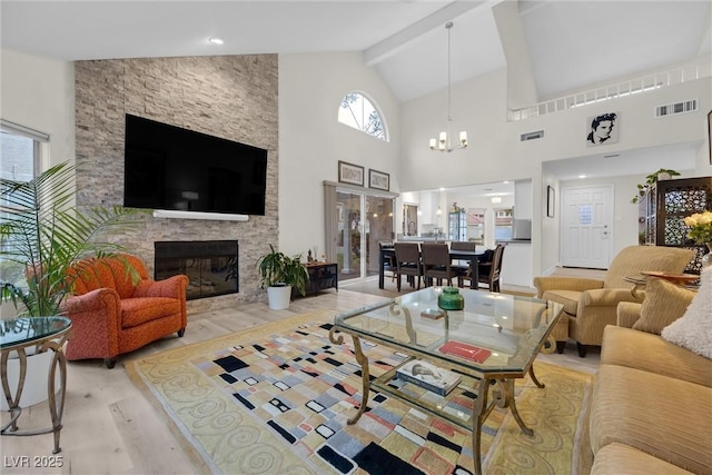 living room with an inviting chandelier, high vaulted ceiling, a fireplace, beamed ceiling, and light wood-type flooring