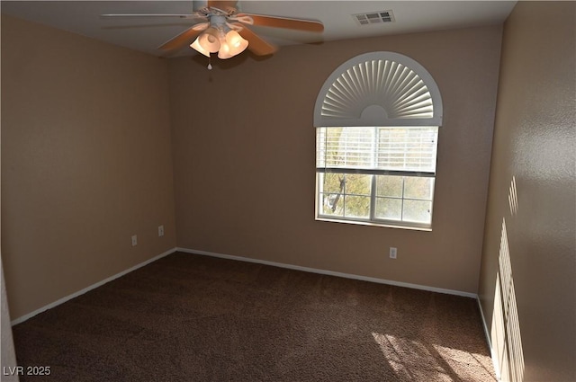 empty room featuring dark carpet and ceiling fan