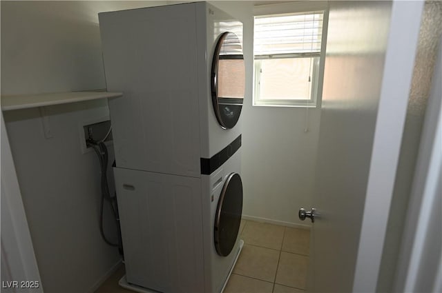 laundry area featuring stacked washer and dryer and light tile patterned floors