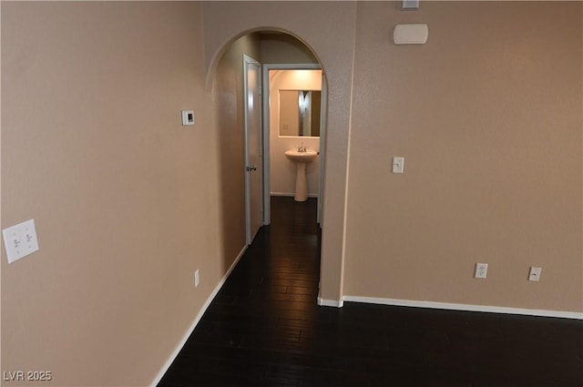 hall with sink and dark wood-type flooring