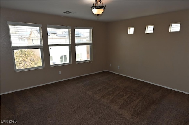 spare room with dark carpet