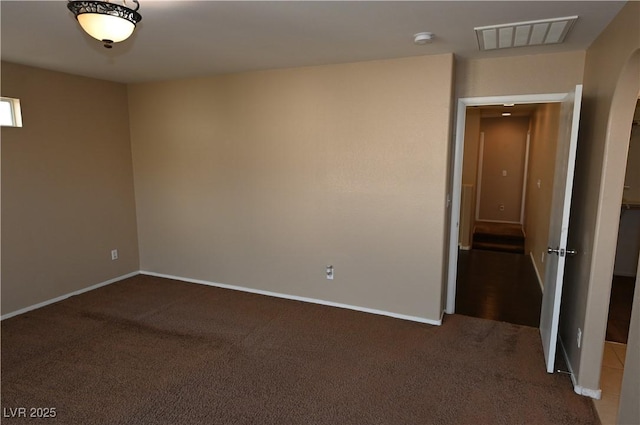 unfurnished room with dark carpet