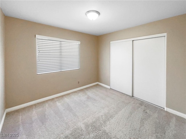 unfurnished bedroom featuring light colored carpet and a closet