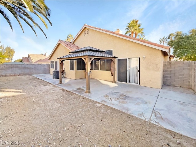 rear view of house with cooling unit, a gazebo, and a patio