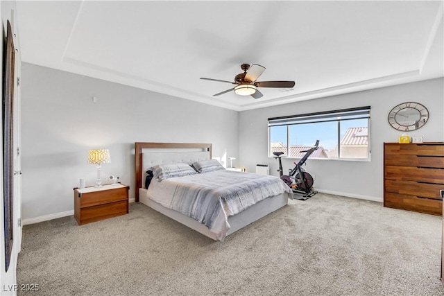 bedroom with carpet floors, a raised ceiling, and ceiling fan