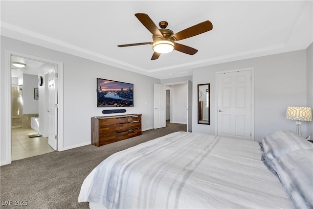 carpeted bedroom featuring ceiling fan, a tray ceiling, and connected bathroom