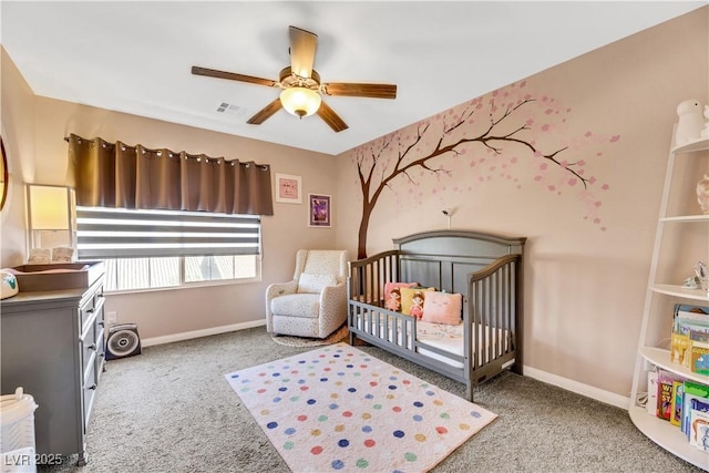 bedroom featuring ceiling fan, light carpet, and a crib