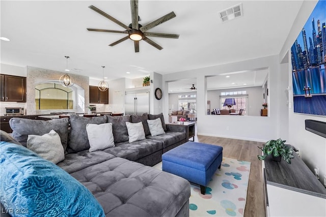 living room featuring ceiling fan and light wood-type flooring