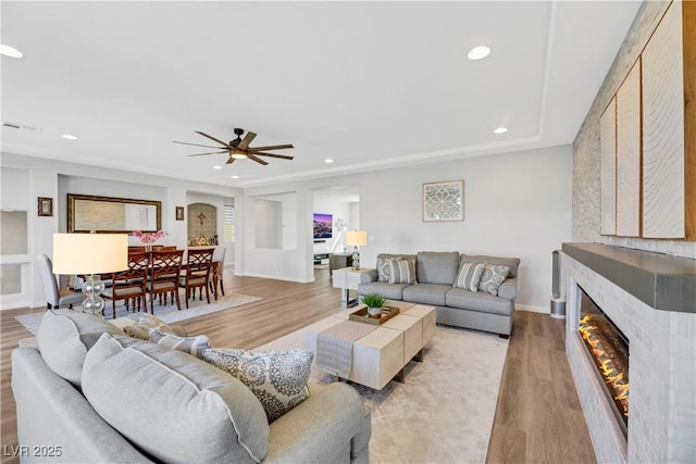 living room with ceiling fan and light hardwood / wood-style floors