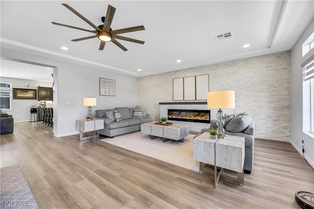 living room with light hardwood / wood-style flooring and ceiling fan