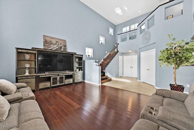 living room featuring dark wood-type flooring and a high ceiling