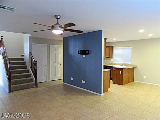 kitchen featuring black dishwasher, sink, ceiling fan, and kitchen peninsula