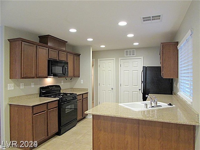 kitchen with light stone counters, light tile patterned floors, sink, and black appliances