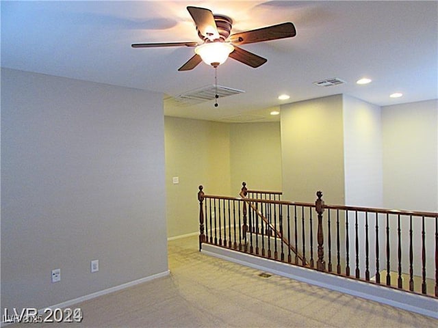 empty room featuring ceiling fan and light colored carpet