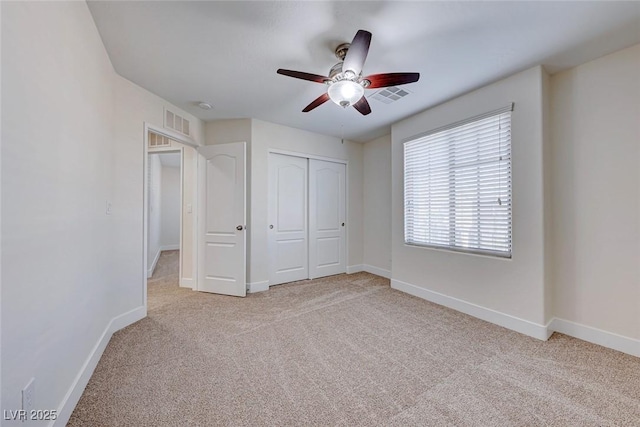 unfurnished bedroom featuring ceiling fan, light carpet, and a closet