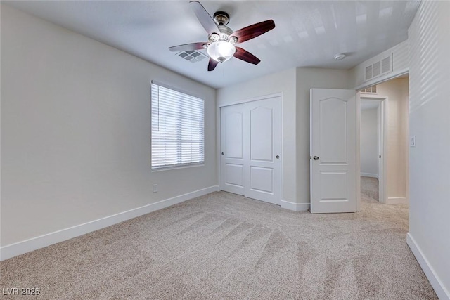 unfurnished bedroom with light carpet, ceiling fan, and a closet