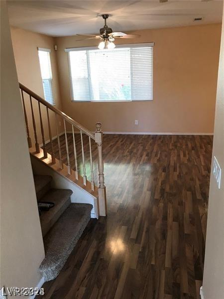 staircase with hardwood / wood-style flooring and ceiling fan